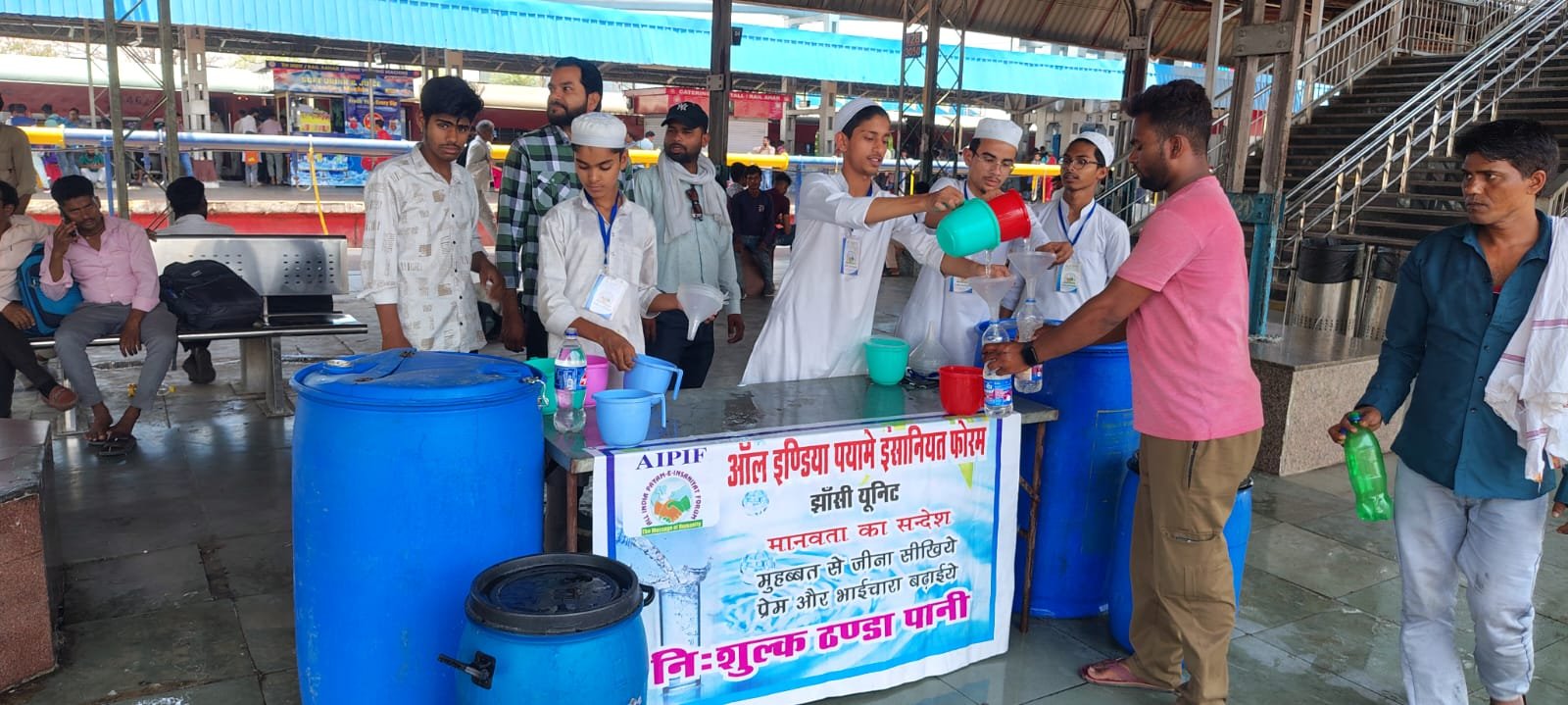 AIPIF volunteers serving food and drinks to passengers at a railway station